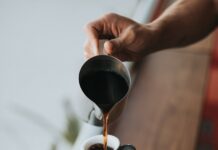 커피 대신 마테·히비스커스? 카페인 대체 열풍 person holding gray stainless steel pitcher bside window