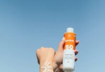 여름철, 피부를 건강하게 유지하는 5가지 방법 a person holding a bottle of sunscreen in their hand