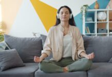 변화하는 정신건강 트렌드, ‘마음 챙김’이 일상 속으로 Woman meditating on couch with headphones on