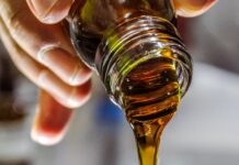 ‘오일풀링’으로 입속 건강 지키기… 일상 속 실천법 주목 person holding clear drinking glass with brown liquid