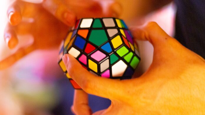 Photo by ALAN DE LA CRUZ person holding 3 x 3 rubiks cube