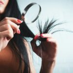 건강한 모발을 위한 똑똑한 헤어 관리, 일상 속 실천법은? Woman examining split ends of hair with magnifying glass