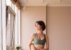 집과 직장에서 더 가까워진 필라테스, 건강한 일상을 만드는 실천법 a woman in a green sports bra top and leggings holding a yoga mat