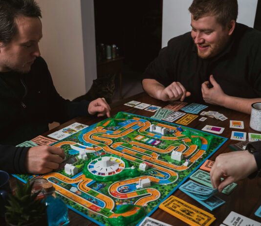 “뇌 건강 지키기, 생활 속 작은 실천에서 시작된다” two men playing a game of monopoly on a table